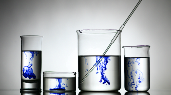 This is an image of chemistry glass holding water. Blue dye is poured into the water to resemble oil in water.